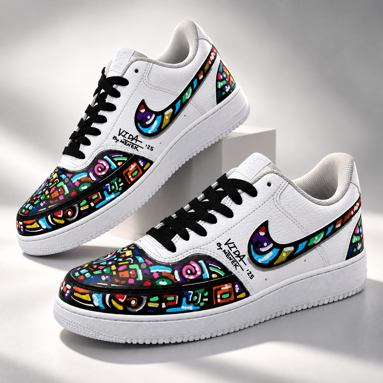 White sneakers with black laces and colorful hand-painted VIDA artwork by Mènek